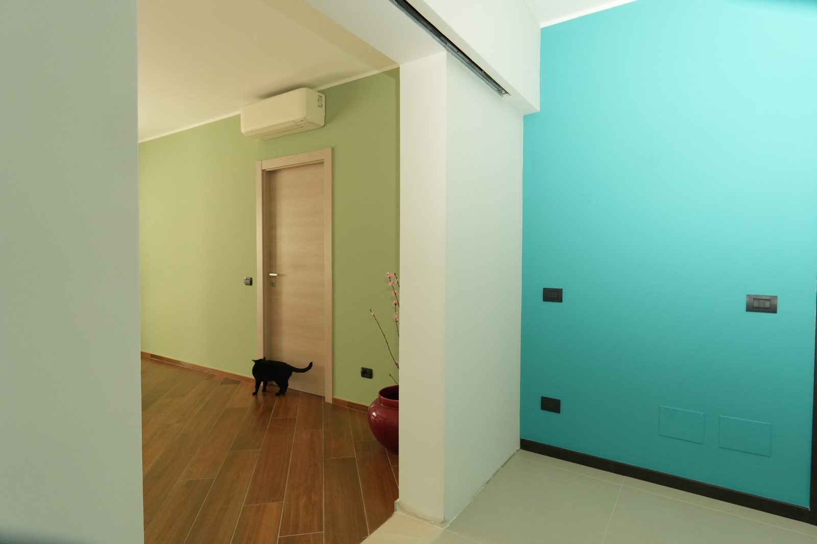 Corridoio con pareti verde salvia e tiffany