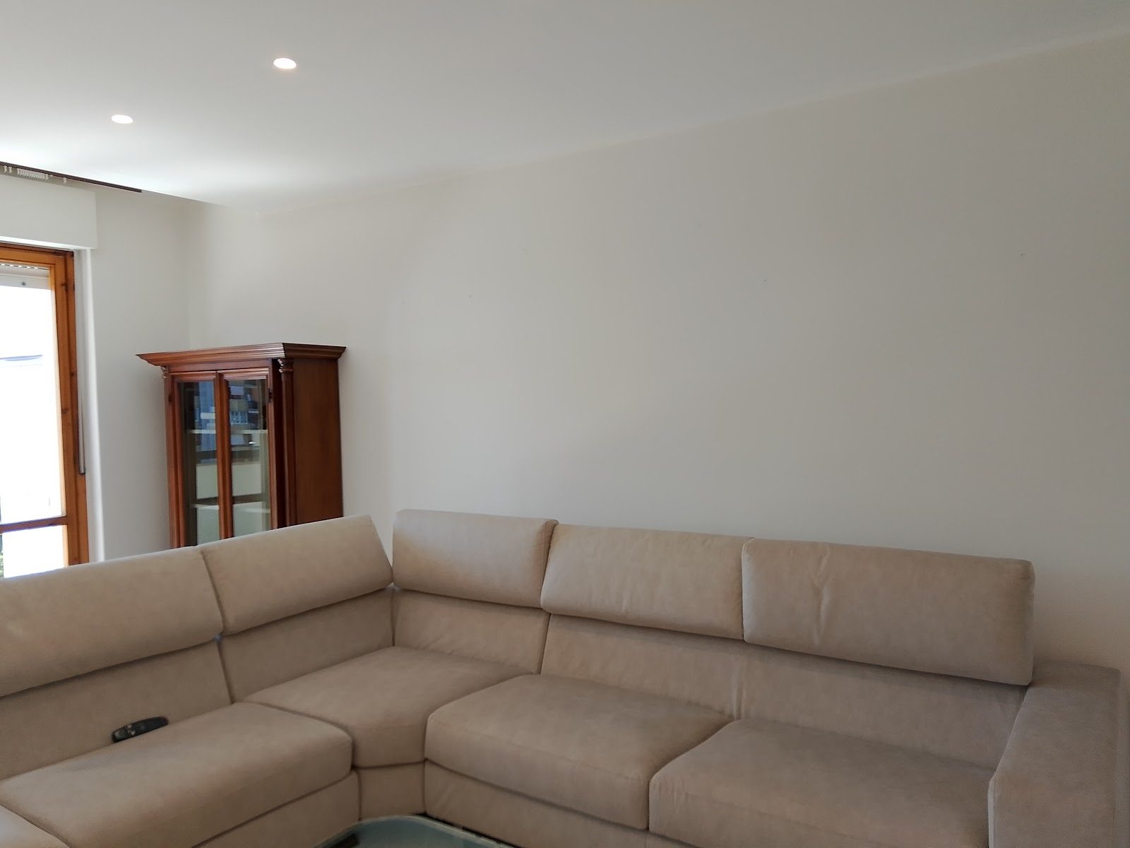 Soggiorno con pareti bianche e divano beige